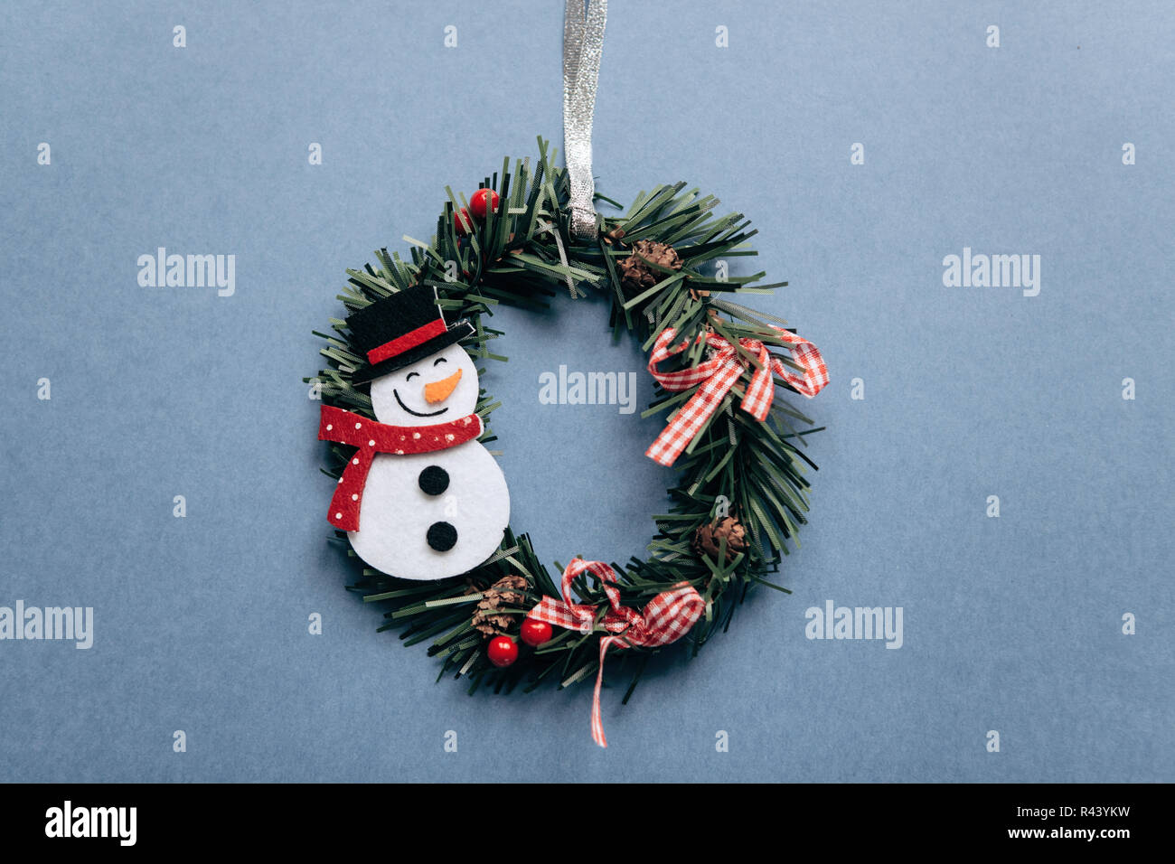 Corona de navidad con muñeco de nieve árbol de Navidad sobre fondo azul de  juguete creativa idea festiva en estilo minimalista. El minimalismo  Fotografía de stock - Alamy