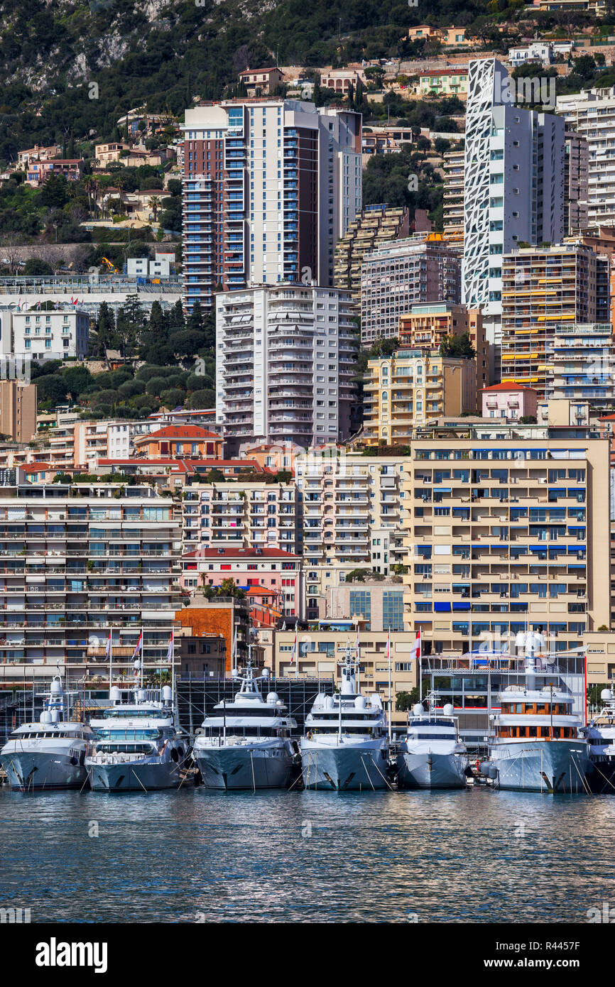 Principado de Mónaco, yates, edificios de apartamentos, bloques de pisos, casas en una empinada ladera de montaña costera Foto de stock