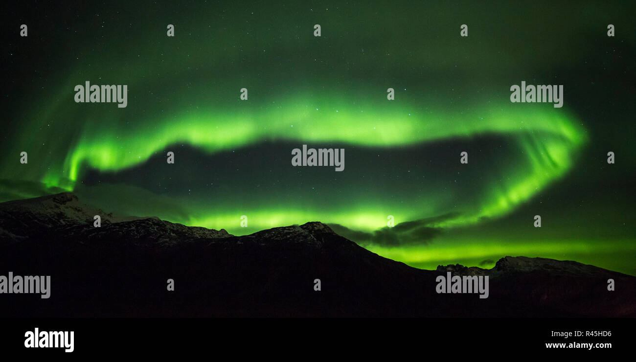 Las auroras boreales (aurora borealis) sobre el fiordo en la región de Troms, Noruega Foto de stock