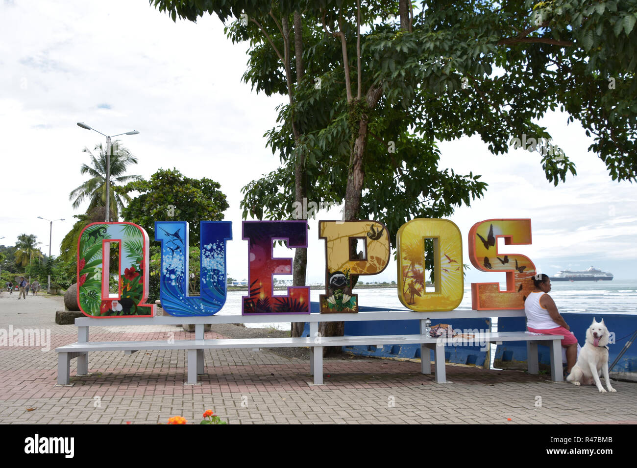 Signo de la ciudad de Quepos, Costa Rica a lo largo de la playa. Crucero en el fondo Foto de stock