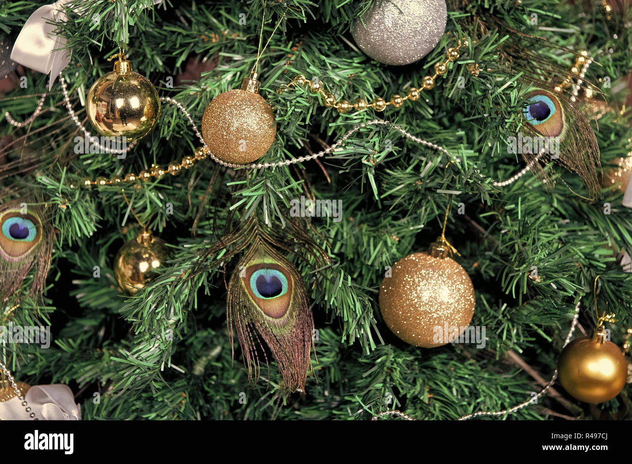 Árbol de Navidad con bolas, guirnaldas, plumas de pavo real sobre fondo  verde. Navidad y Año Nuevo. Decoraciones festivas y ornamentos. Vacaciones  de invierno prep Fotografía de stock - Alamy