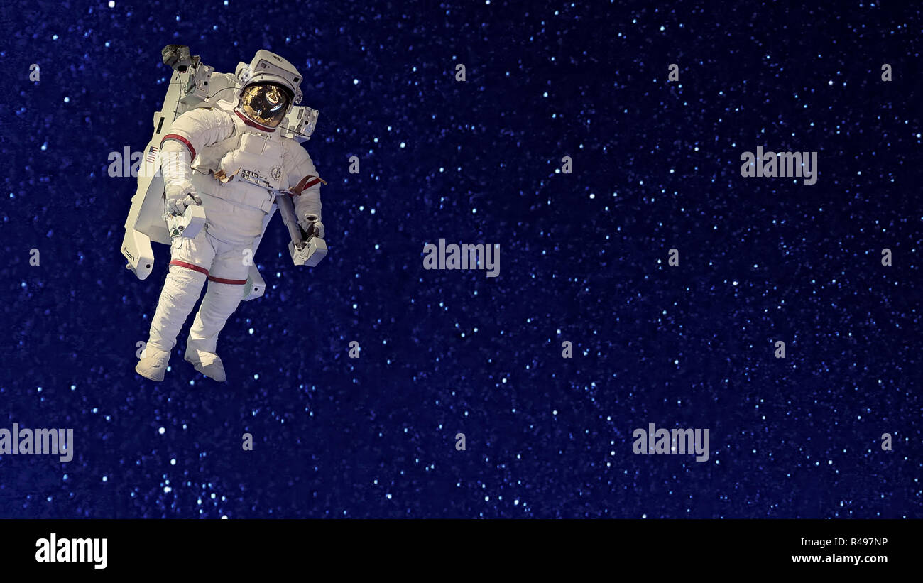 Un astronauta en traje espacial flotando en la negrura del espacio frente a un fondo de estrellas Foto de stock