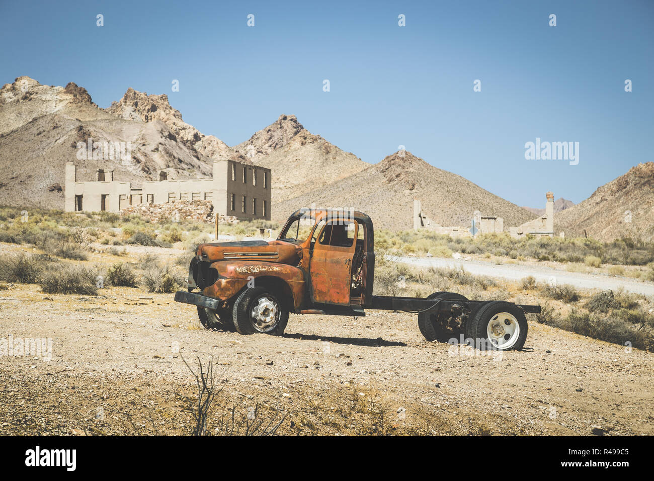 Vista clásica de una vieja camioneta oxidada de un accidente automovilístico en el desierto, en un hermoso día soleado con el cielo azul en verano con filtro de efecto vintage retro Foto de stock
