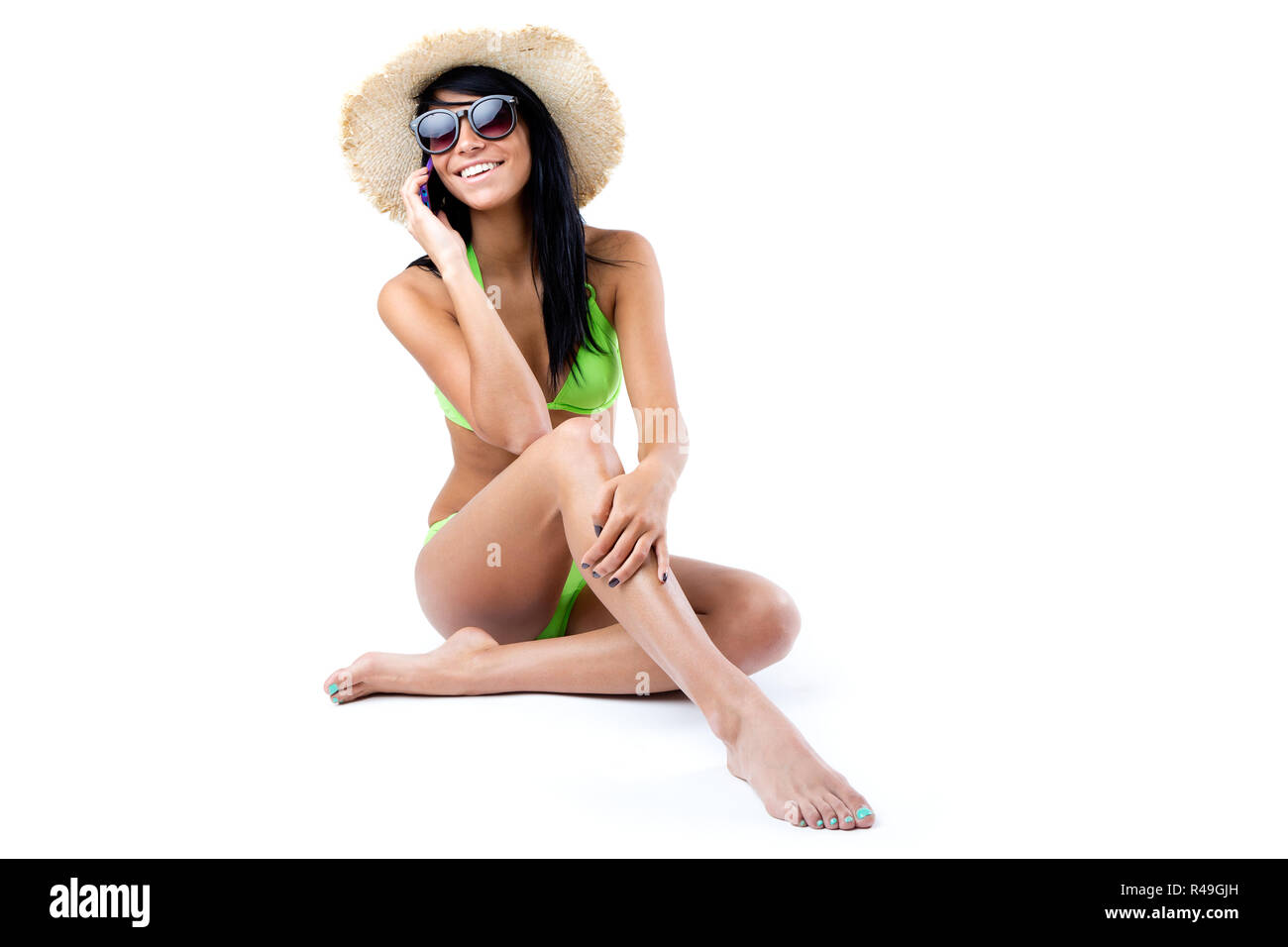 Feliz chica con bikini verde hablando por teléfono móvil Foto de stock