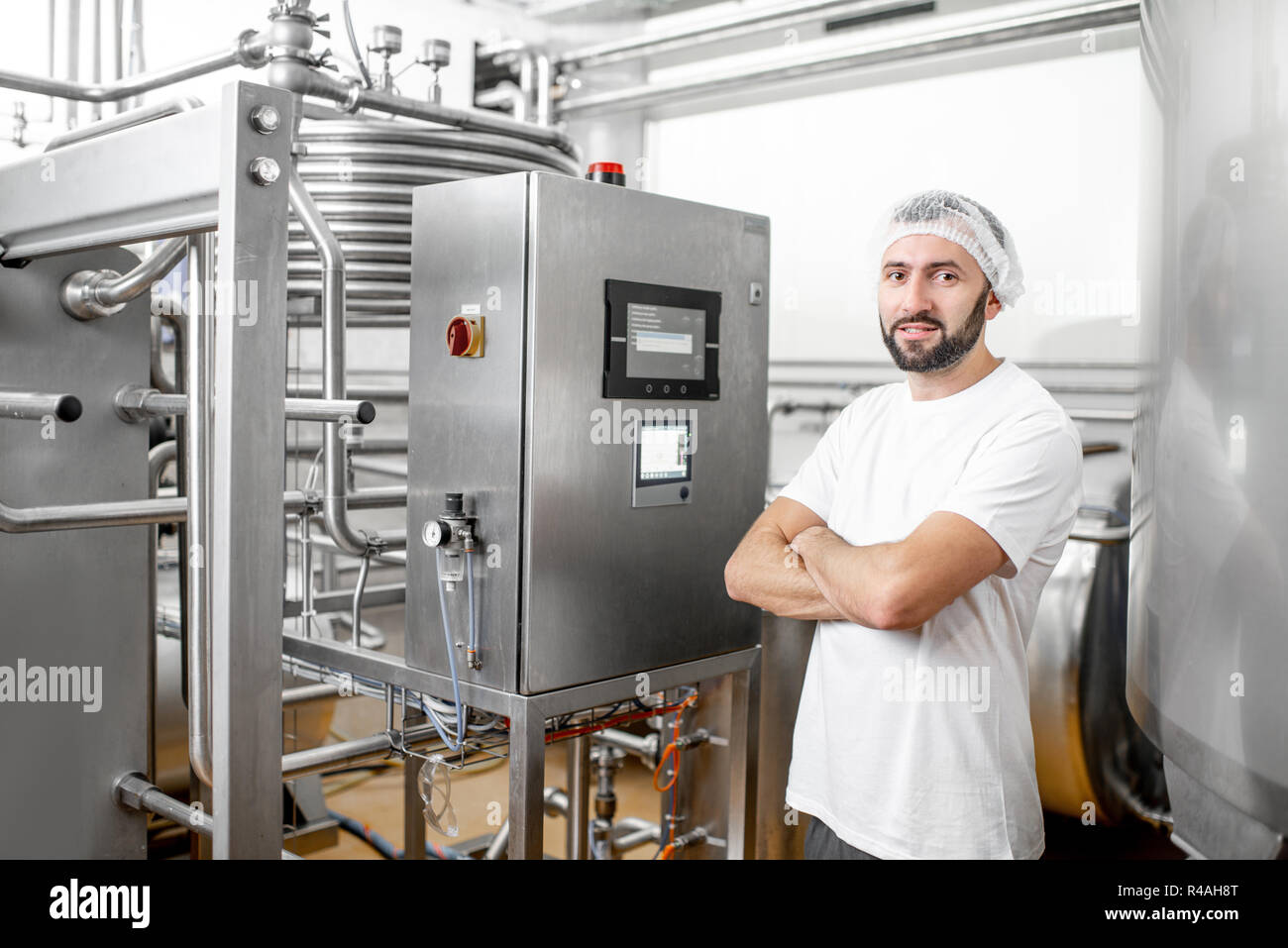 El pasterizador operativo trabajador utilizando el panel de control en