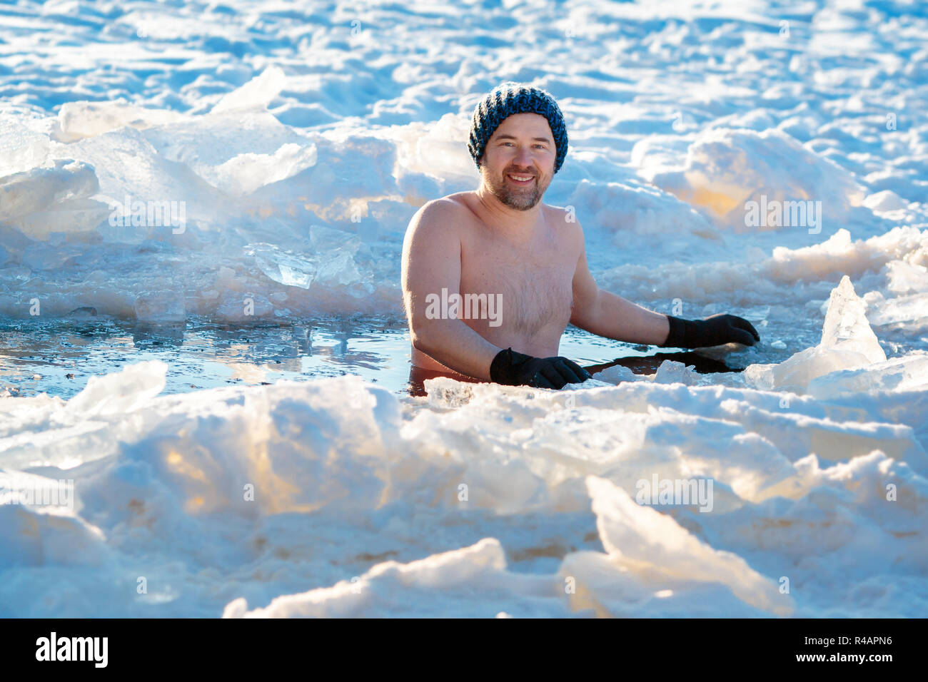 Piscina de Invierno. Hombre valiente en un agujero de hielo. Foto de stock