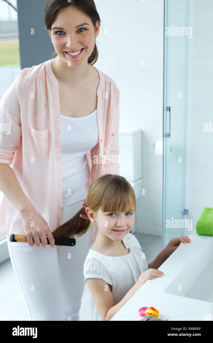 Madre peinando a su hija en el baño Fotografía de stock - Alamy