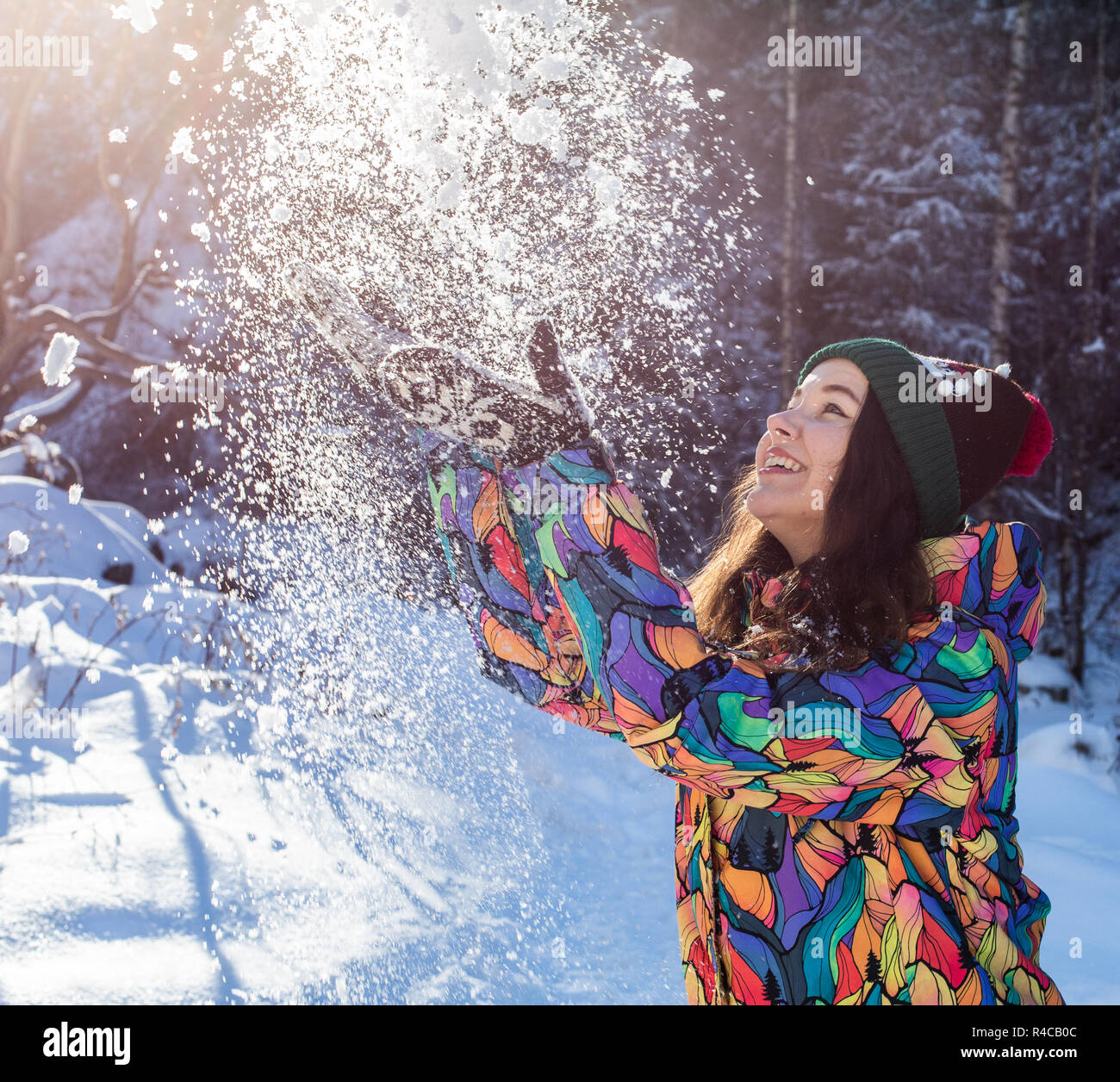 Mujer Joven Con Orejeras Y Hombre Alegre Con Sombrero De Invierno Apoyado  En Un Borde De Madera En Una Pista De Hielo Fotos, retratos, imágenes y  fotografía de archivo libres de derecho.