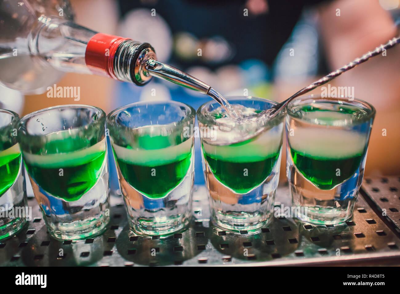 Líquido verde en shot gafas, de pie en el mostrador. barman prepara disparos Foto de stock