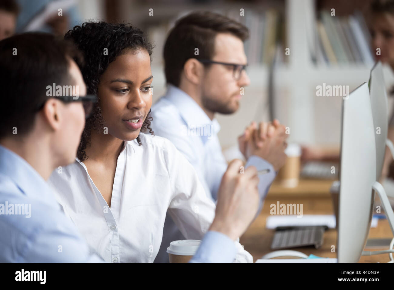 Grave joven afroamericana hablando con su colega Foto de stock