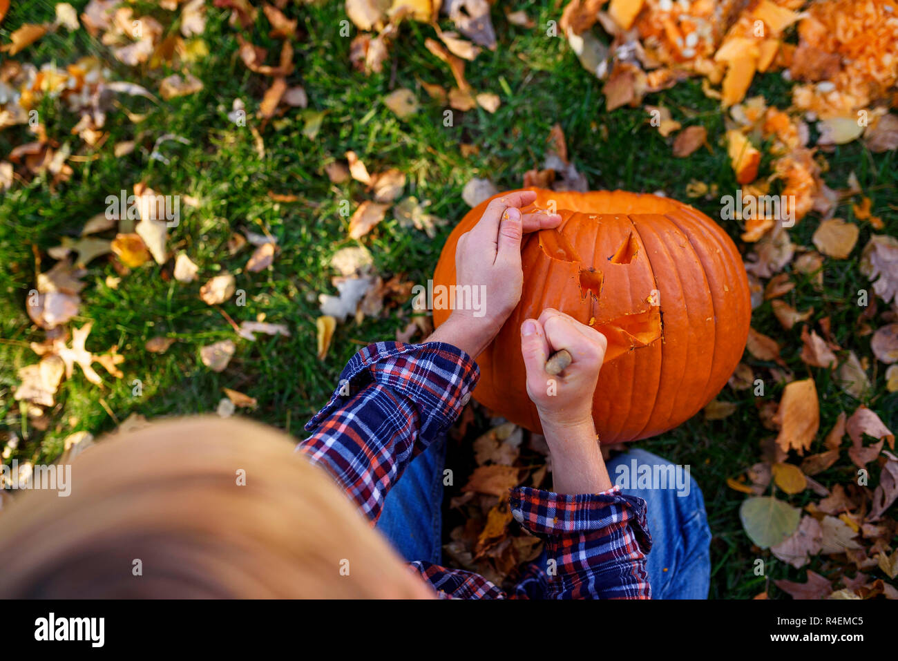 Boy tallando una calabaza de Halloween en el jardín, Estados Unidos Foto de stock