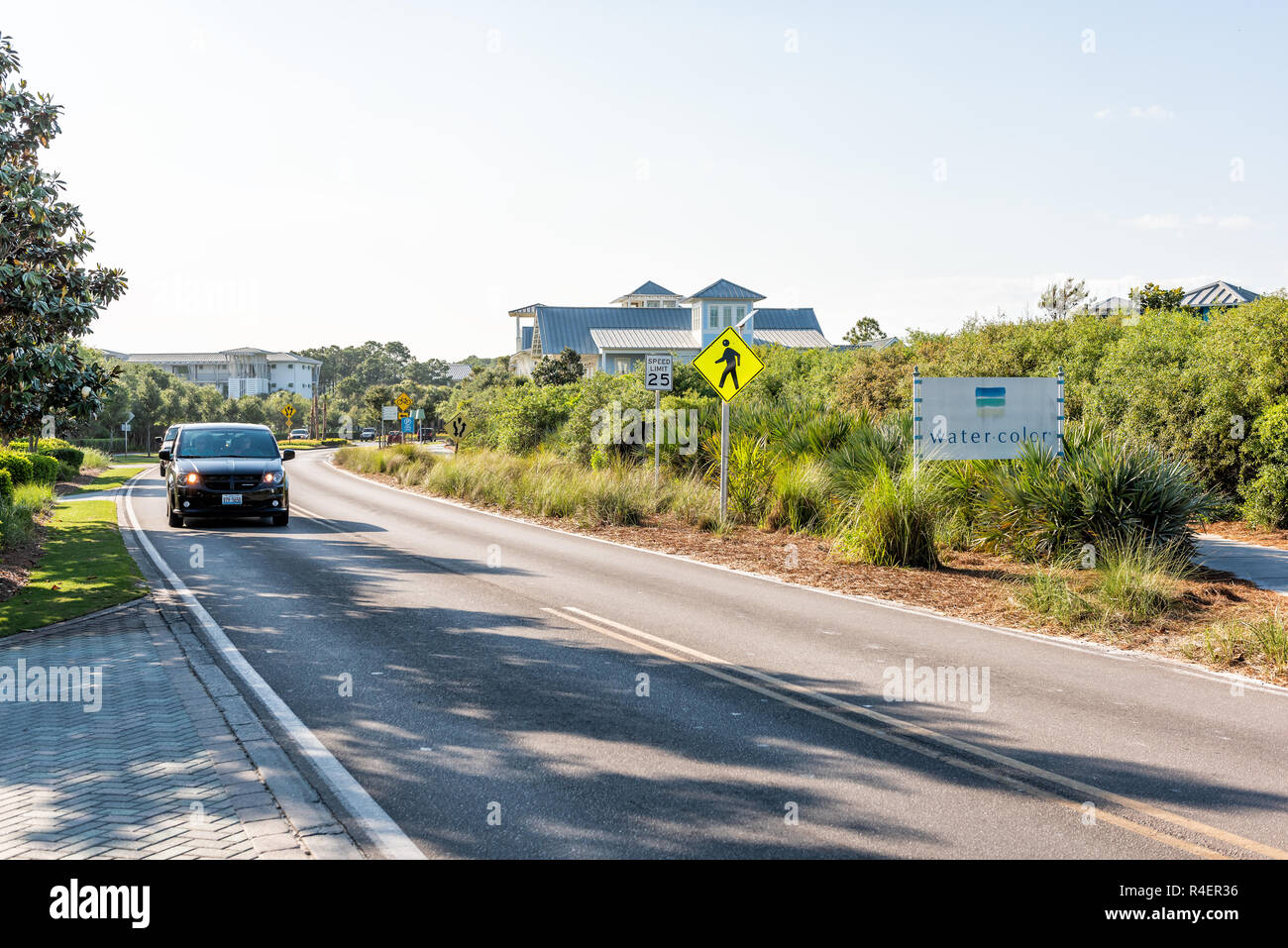 Seaside, ESTADOS UNIDOS - 25 de abril de 2018: Acuarela inn aguas color firmar en la carretera con los coches en la ciudad aldea por la playa durante el día soleado en la Florida Panhandle g Foto de stock