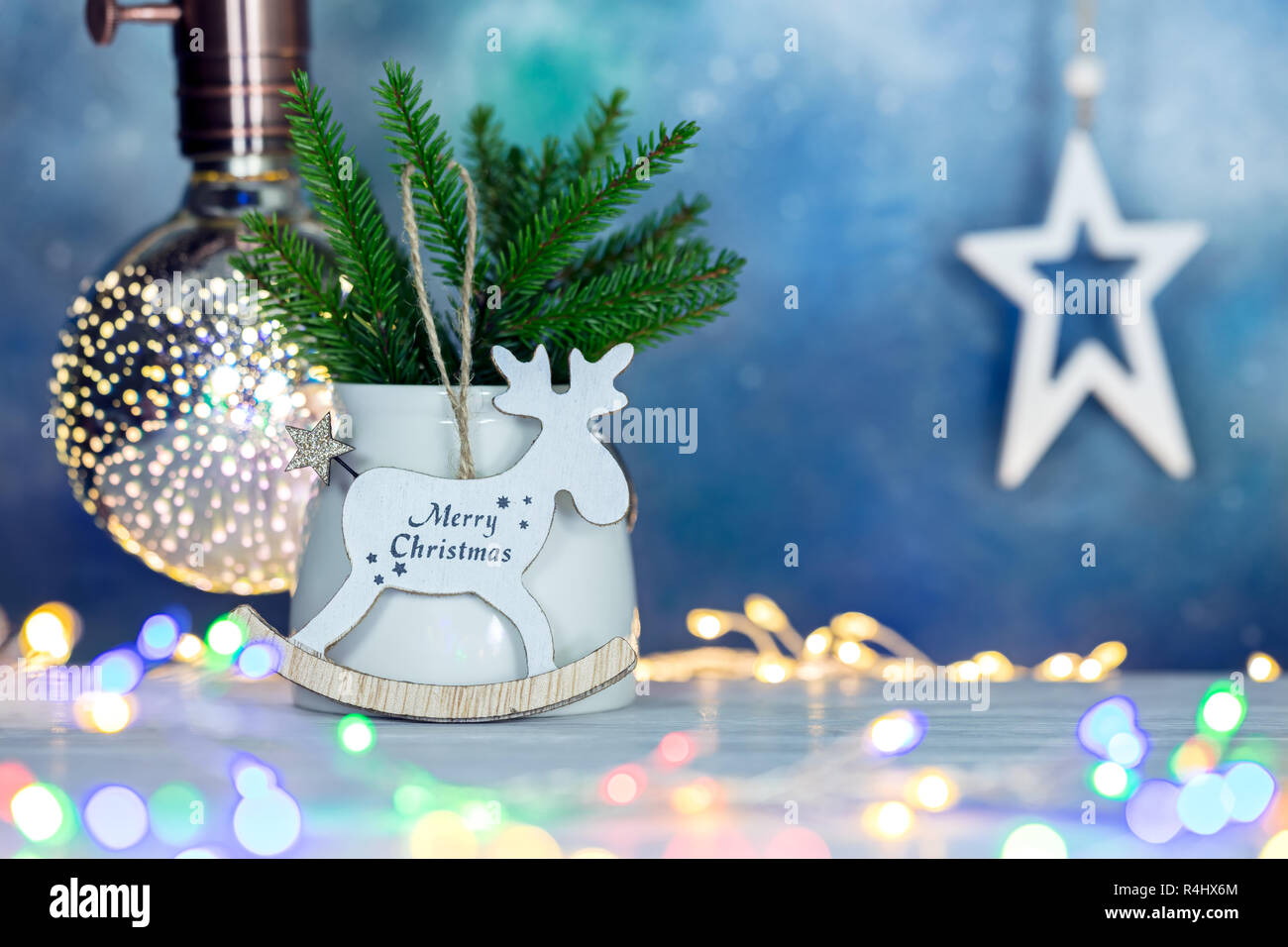 Decoraciones de año nuevo. árbol de navidad ramo verde y decoración en madera contra borrosas luces brillantes antecedentes Foto de stock