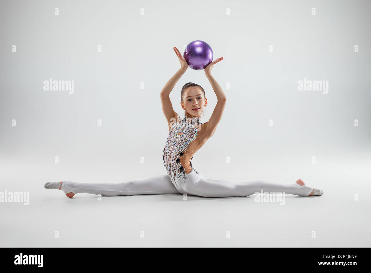 Las mujeres adolescentes niña haciendo gimnasia ejercicios con pelota sobre  un fondo gris de studio. La gimnasia, estirar, gimnasio, estilo de vida,  formación, deporte concepto Fotografía de stock - Alamy