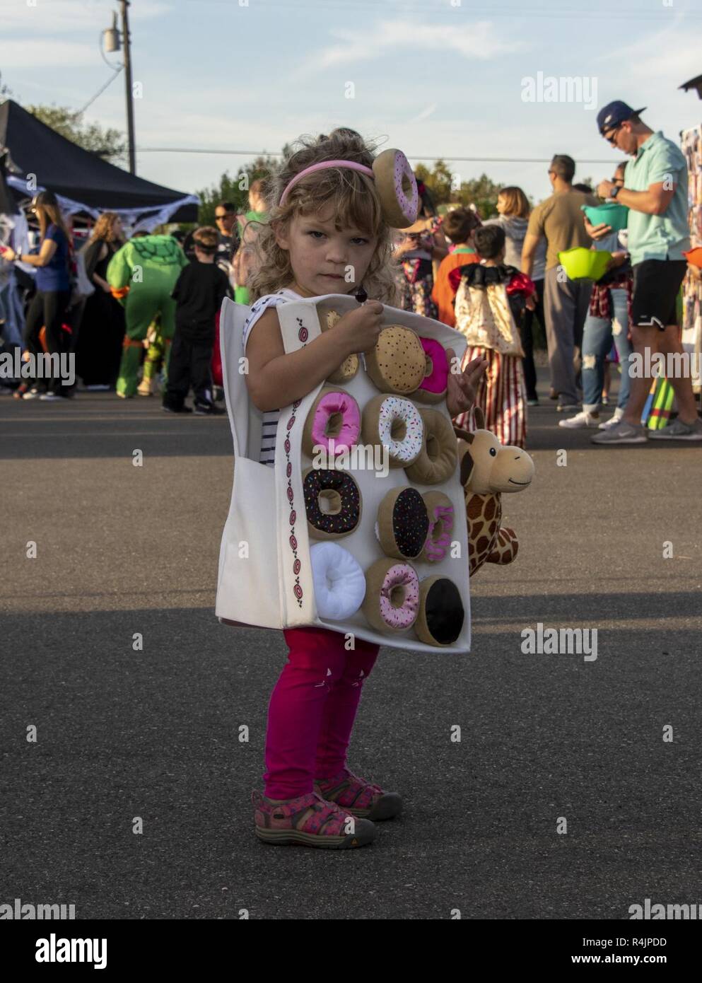Amplia gama Español Hija Una niña vestida como una caja de donuts goza de un convite, 26 de octubre  de 2018, Travis Air Force Base, California. El Aviador y Family Readiness  Centro organizó la Octava Ceremonia