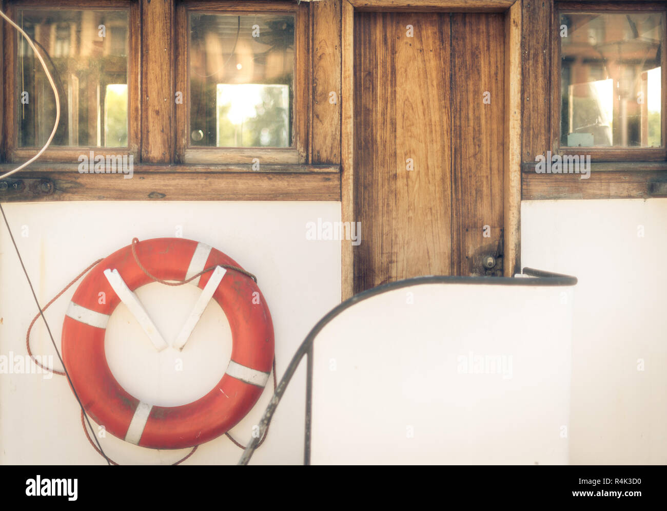 Salvavidas naranja en vintage barco blanco en puerto Foto de stock