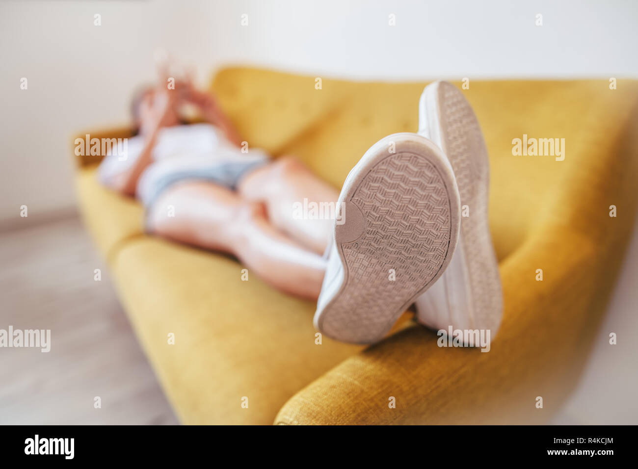 Mujer joven relajante para dormir en el sofá en casa. Se centran en pie. El concepto de descanso Foto de stock