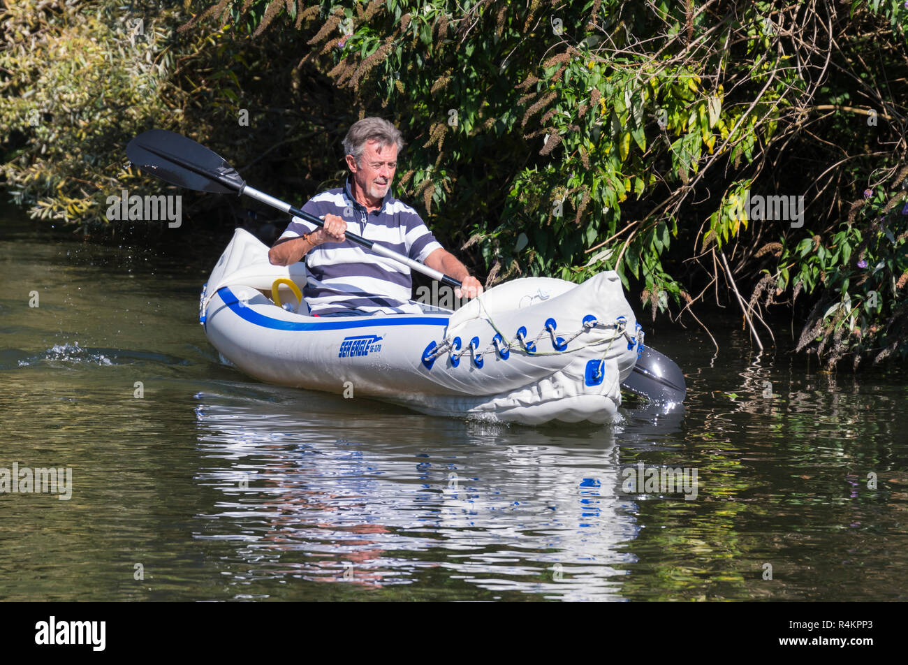 Un varón de mediana edad remando con un remo de doble hoja en un Águila de Mar SE-370 kayak inflable, en un canal en el Reino Unido. Foto de stock