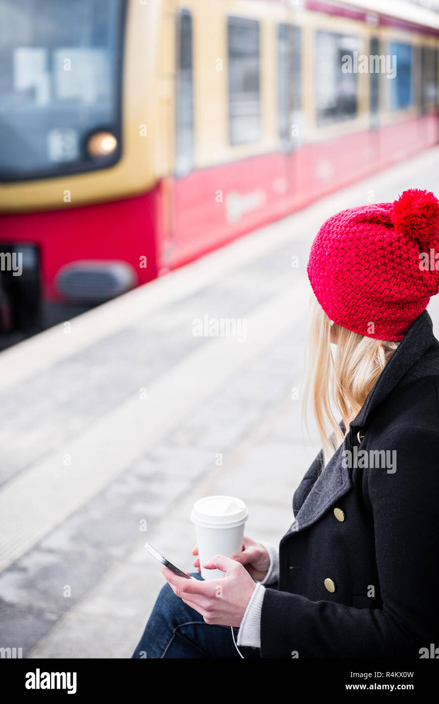 Mujer esperando en la estación de tren suburbano Foto de stock