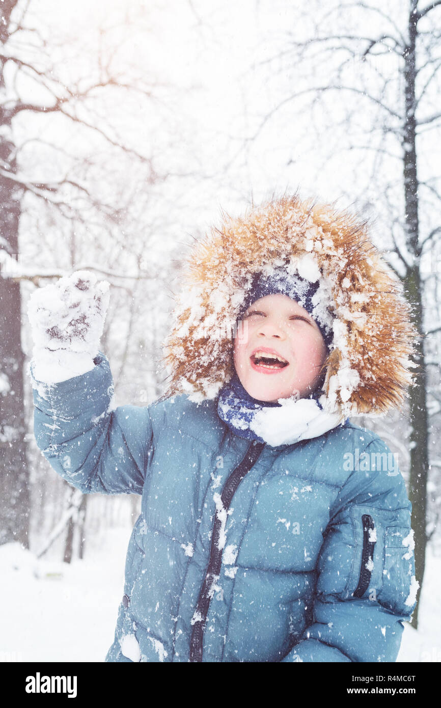 Niño jugando con nieve en Winter Park. Navidad diversión de invierno. Hermoso clima invernal. Foto de stock