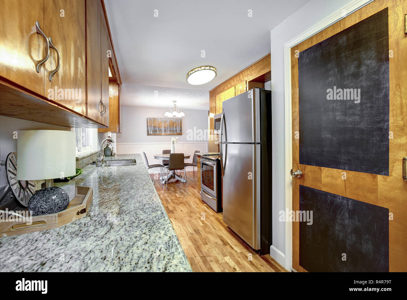Una cocina renovada con armarios blancos, una encimera de madera natural,  sillas sentadas en la isla, y un chapoteo de azulejos verde del metro  Fotografía de stock - Alamy