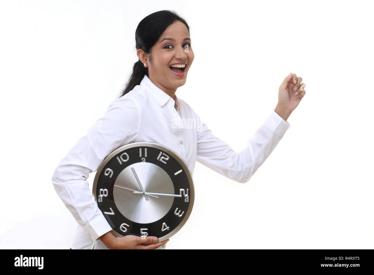 Mujer de negocios en marcha y mantiene un reloj contra el fondo blanco. Foto de stock