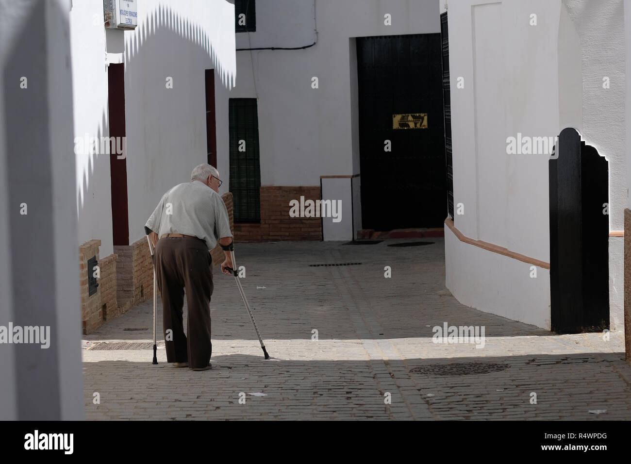 Un viejo hombre español caminando en una ciudad pequeña. Foto de stock