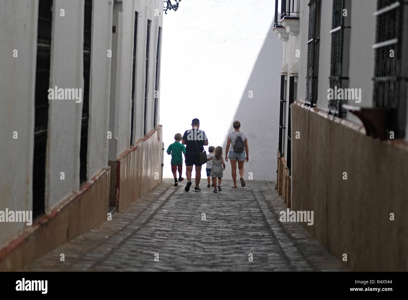Una familia de vacaciones, explorar las callejuelas de una ciudad española. Foto de stock