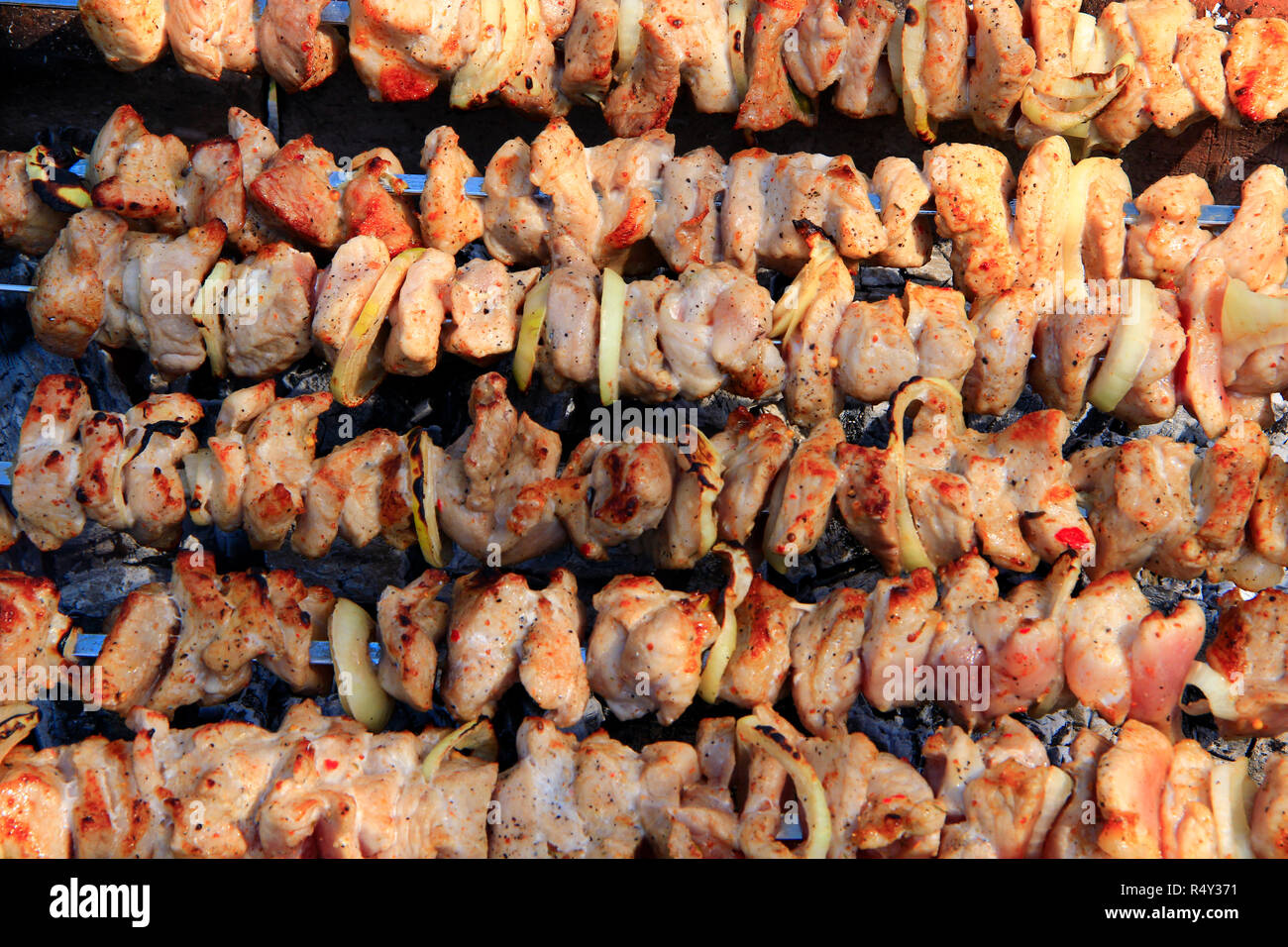 Apetitoso closeup pinchito. Carne de cerdo cocinada. Almuerzo barbacoa al aire libre. Los cubos de carne de cerdo a la parrilla. Pinchito preparado sobre una parrilla a la brasa Foto de stock