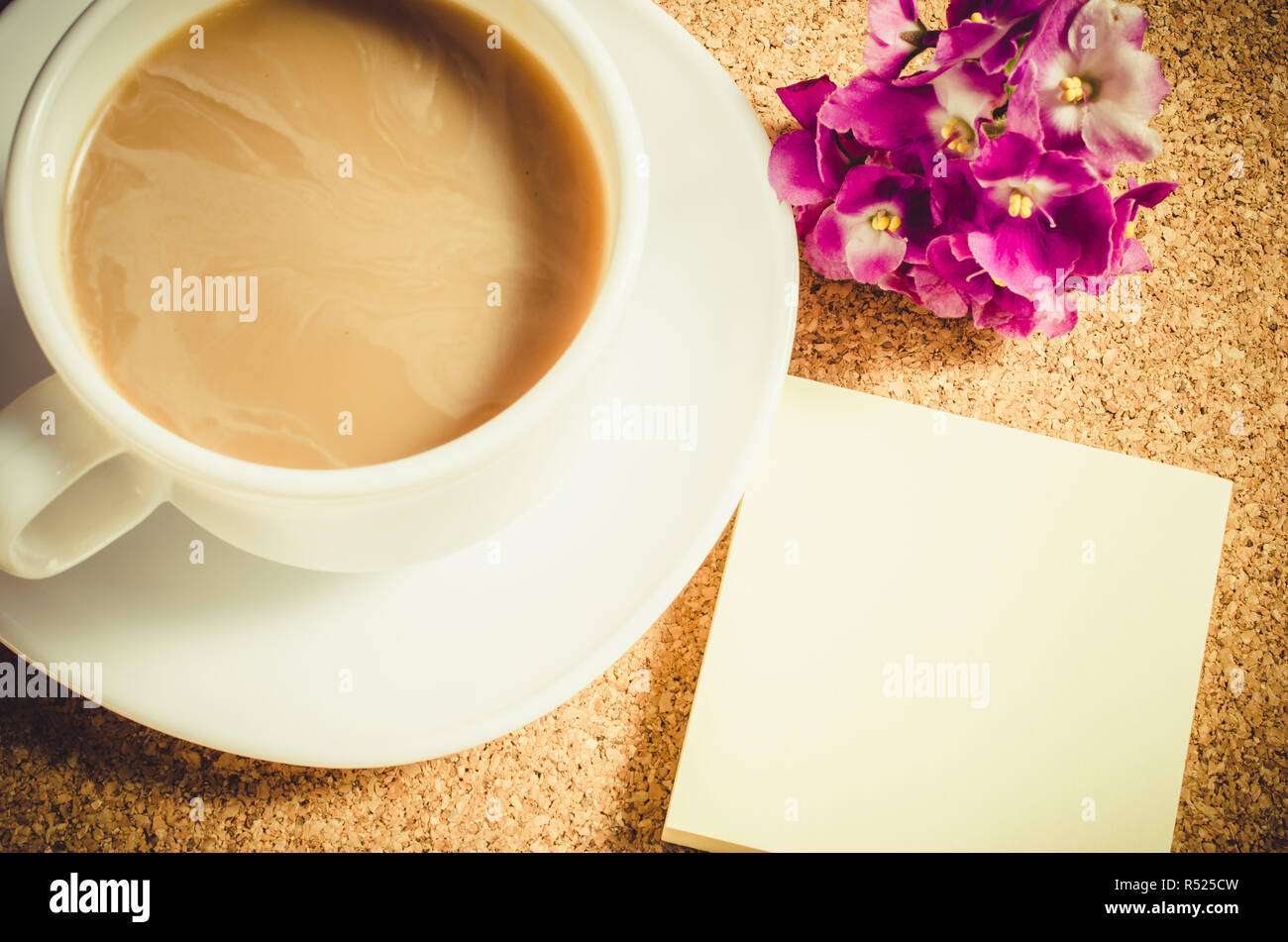 Taza de café con flores en el tablero de corcho. Foto de stock