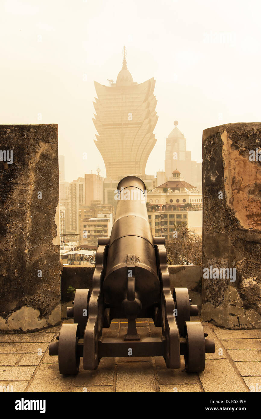 El paisaje en el horizonte desde Macao Guia Fortress (Fortaleza da Guia) con viejos cañones de hierro en primer plano Foto de stock