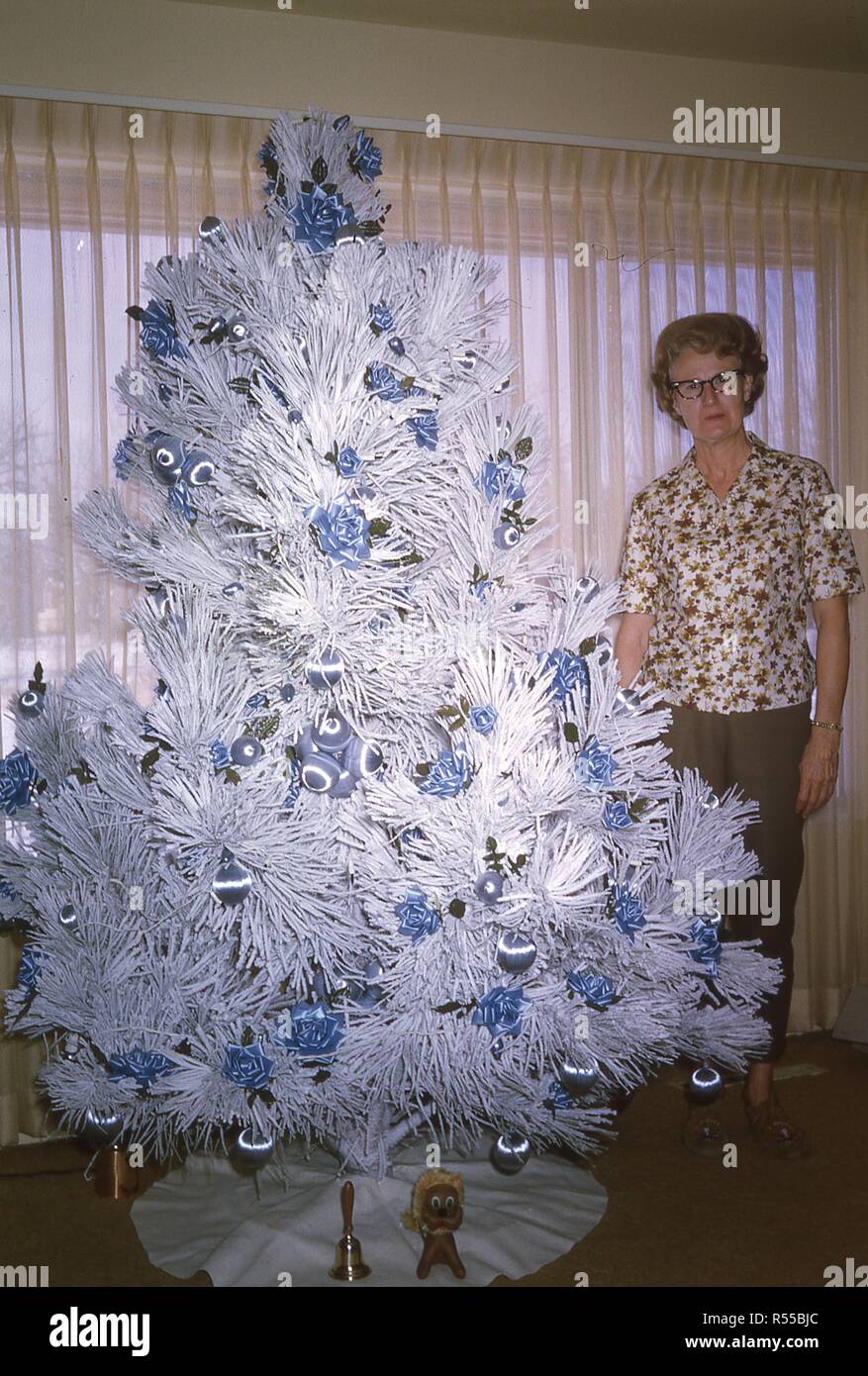 Retrato de una mujer posando con su blanco-pino afelpada del árbol de  Navidad, decorado con adornos de color azul, 25 de diciembre de 1966  Fotografía de stock - Alamy
