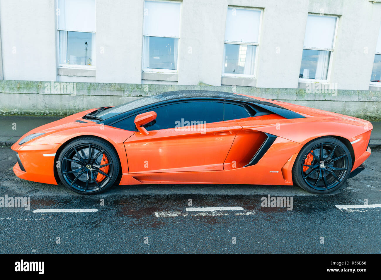 Lamborghini naranja en la calle Fotografía de stock - Alamy