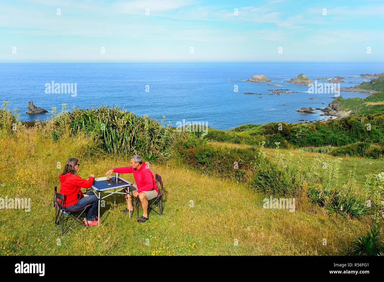 Par juega juegos de tablero de mesa de camping, Pacific Coast, Pumillahue, Isla Chiloé, Chile Foto de stock