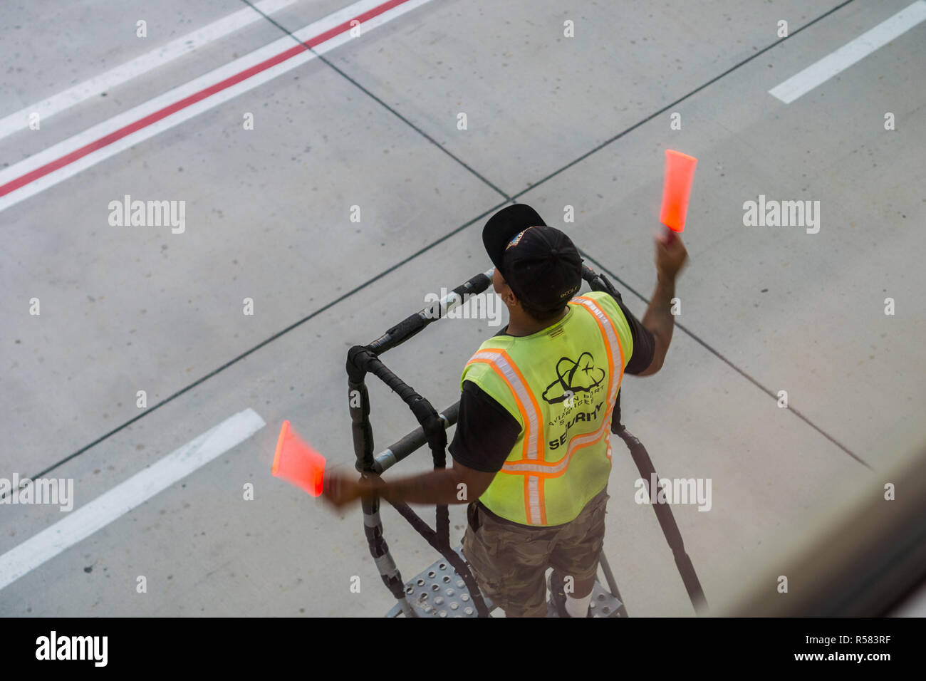 El 9 de septiembre de 2017 San Jose/CA/USA - empleado de seguridad del aeropuerto guiar un avión para el acoplamiento Foto de stock