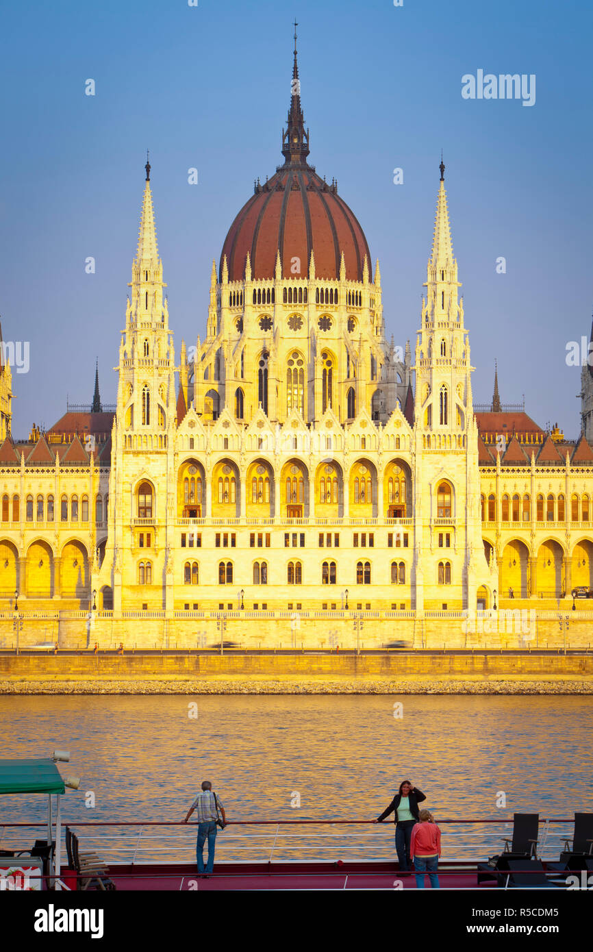 Edificio del Parlamento húngaro y el río Danubio iluminado al atardecer, Budapest, Hungría Foto de stock