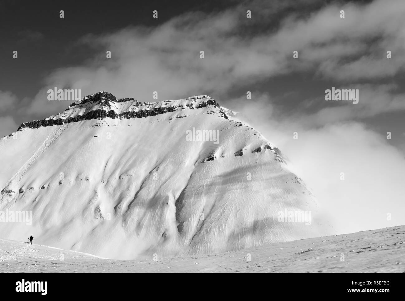 Esquiador fuera de pista y pendiente con huellas de esquíes, tablas de snowboard y avalanchas. Montañas del Cáucaso en las nubes en sun día de invierno, Georgia, la región de Gudauri. Bla Foto de stock