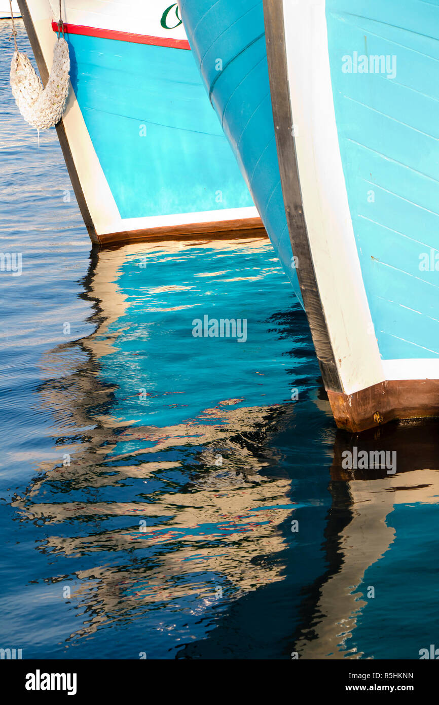 Borroso reflejo de madera barcos azul arco en el mar Foto de stock