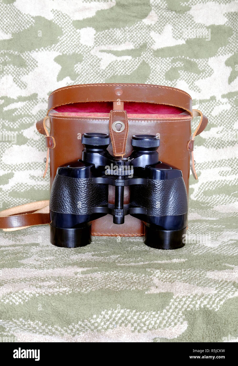 Vintage militar inglés prisma Porro prismáticos de color negro con marrón  abierto estuche de cuero con correa en el camuflaje de fondo Cerrar vista  frontal Fotografía de stock - Alamy