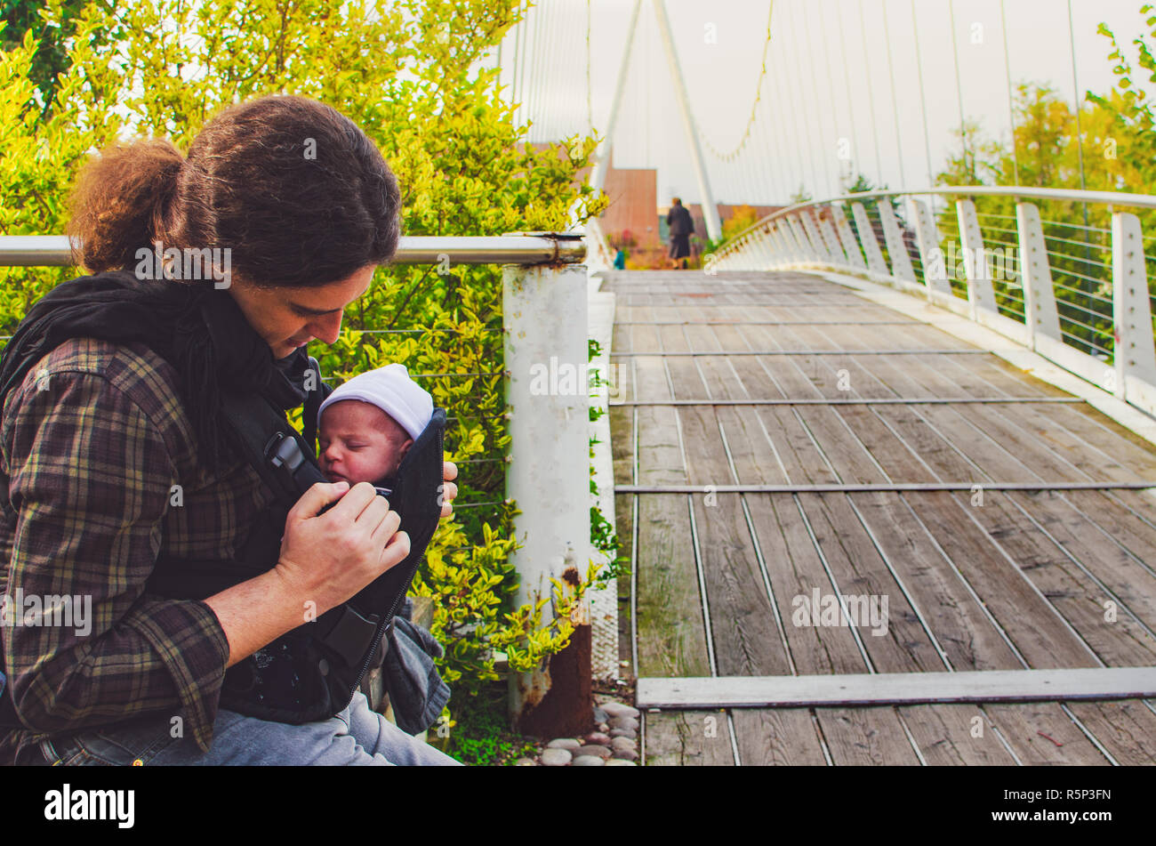 El padre del recién nacido juntos park Baby carrier paternidad antecedentes Foto de stock