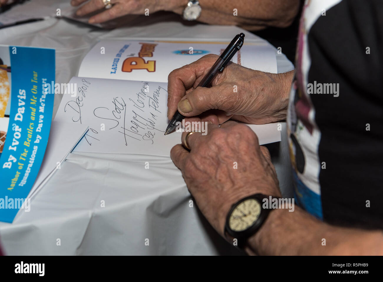 California, EE.UU. El 1 de diciembre de 2018. Autor, Ivor Davis firmaran libros una mano firme en el libro de firma en Pierpont Racquet Club en Ventura, California, EE.UU. el 1 de diciembre de 2018. Crédito: Jon Osumi/Alamy Live News Foto de stock