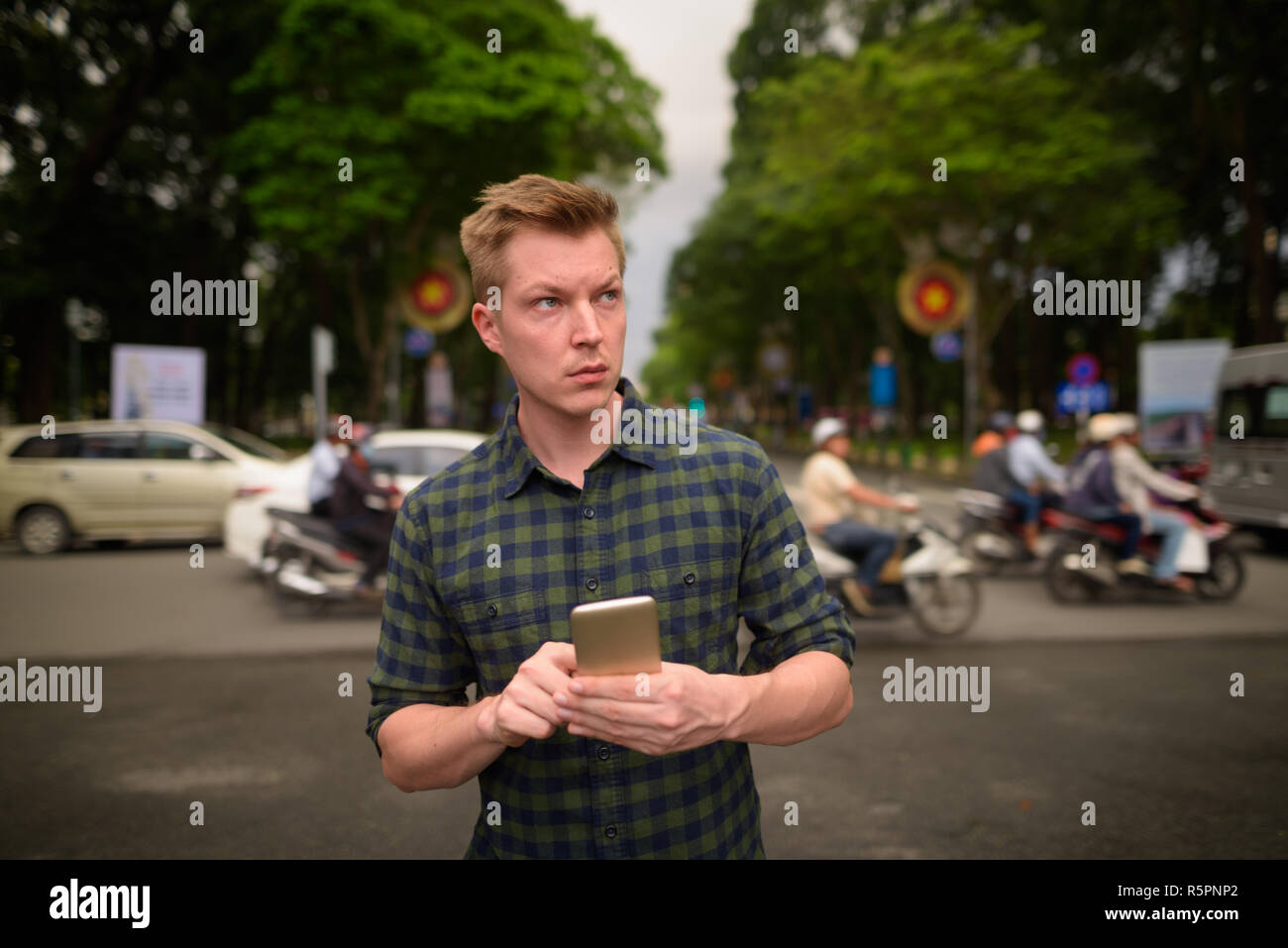 Joven apuesto hombre turística a través de teléfono móvil en Vietnam Foto de stock