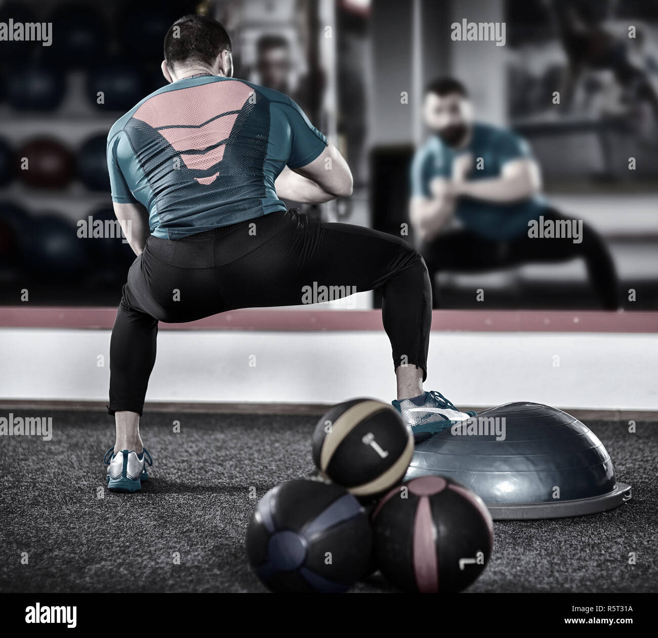 Trainer trabaja con una bola de equilibrio (bosu) en el gimnasio