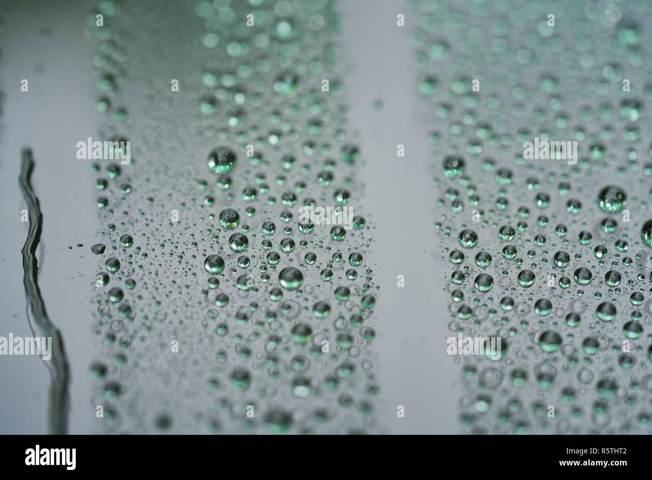 Closeup gotas de lluvia sobre alquiler de vidrio con recubrimiento hidrofóbico. Foto de stock