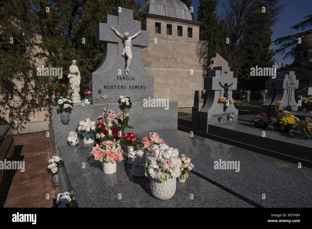 Flores adorna una tumba en el cementerio de La Almudena de Madrid