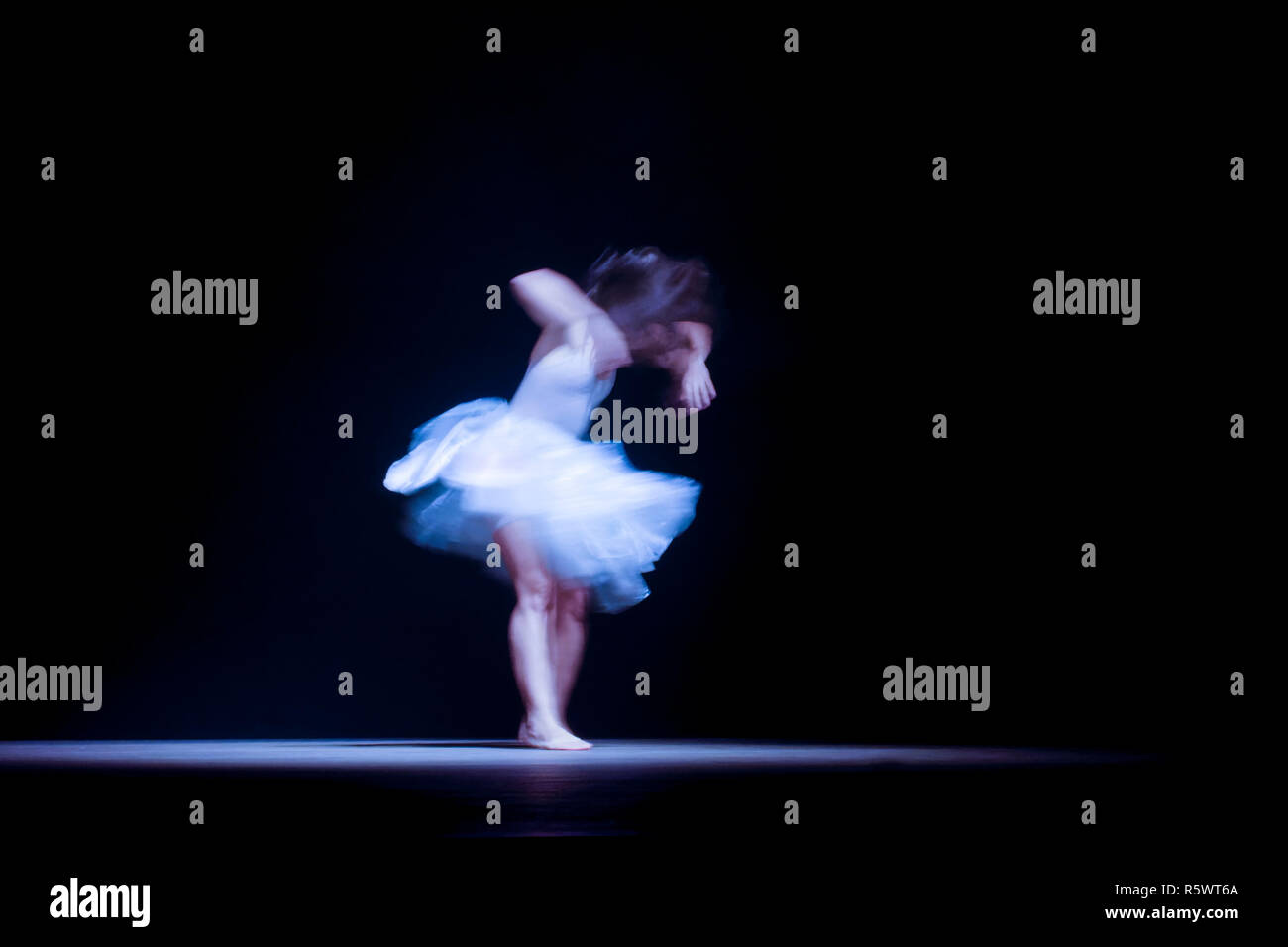 Joven bailarín con movimiento borrosa durante la presentación del espectáculo de danza moderna Foto de stock