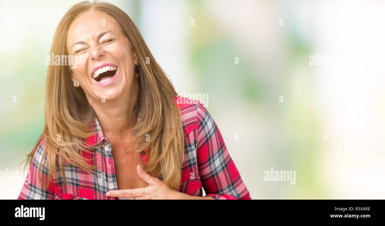 Hermosa mujer de mediana edad vestir con antecedentes aislados sonriendo y riendo duro fuera tan ruidoso porque gracioso broma loco. Expresión feliz. Foto de stock