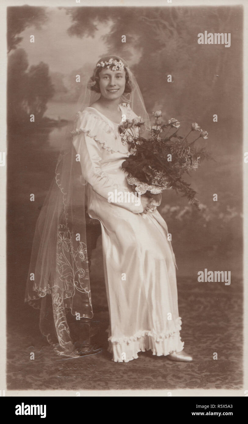 * Plymouth Vintage Postal Fotográfica Real de una dama en su vestido de novia sosteniendo un ramo de flores. Foto de stock