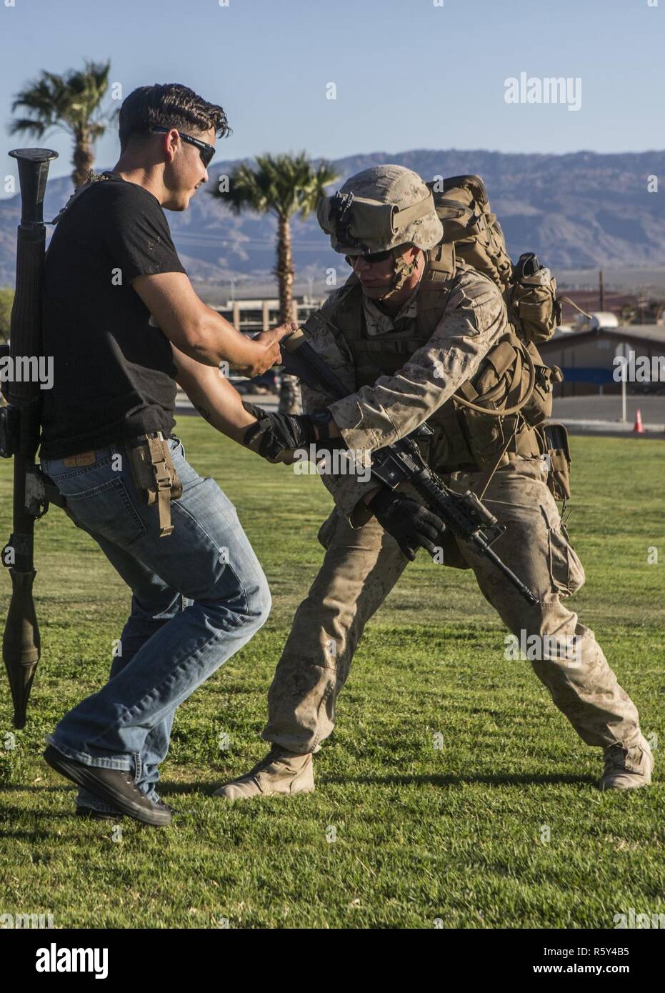 Pfc de Infantería de Marina de los EE.UU. Harley Johnson, un fusilero con Golf Company, Segundo Batallón, 6º Regimiento de la Infantería de Marina, empuja un papel jugadores lejos de él durante el asalto 3 Tácticas de soporte (AST-3) como parte del curso de Instructor de armas y tácticas (WTI) 2-17 en Twenty Nine Palms, California, 21 de abril de 2017. AST-3 es un ejercicio centrado en la realización de la operación de evacuación de no combatientes (NEO) en un entorno urbano, y proporcionando al mismo tiempo la asistencia humanitaria extranjera (FHA) para la simulación de la nación anfitriona. El WTI es un evento de capacitación de siete semanas hospedado por infantes de Marina Aviación Escuadrón de armas y tácticas (MAWTS-1) cad Foto de stock
