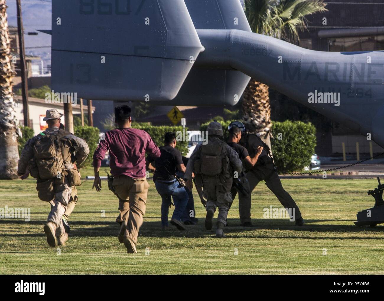 Marines estadounidenses con Golf Company, Segundo Batallón, 6º Regimiento de la Infantería de Marina, y un jefe de tripulación de Infantería de Marina de los EE.UU Con Marines Escuadrón de armas y tácticas de aviación (MAWTS-1) parar los jugadores de rol de embarque una MV-22B Osprey durante el asalto 3 Tácticas de soporte (AST-3) como parte del curso de Instructor de armas y tácticas (WTI) 2-17 en Twenty Nine Palms, California, 21 de abril de 2017. AST-3 es un ejercicio centrado en la realización de la operación de evacuación de no combatientes (NEO) en un entorno urbano, y proporcionando al mismo tiempo la asistencia humanitaria extranjera (FHA) para la simulación de la nación anfitriona. El WTI es un entrenamiento de siete semanas incluso Foto de stock